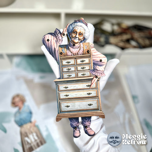 Victorian Granny, a printable articulated paper doll. A masked granny in pink, rising out of a bureau.
