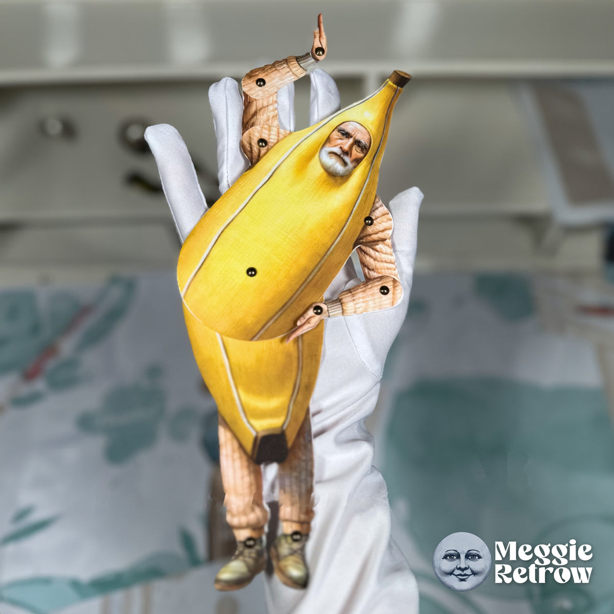 Banana Costume, a printable articulated paper doll. A white-bearded man peering out of a banana peel.