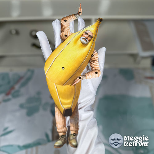 Banana Costume, a printable articulated paper doll. A white-bearded man peering out of a banana peel.