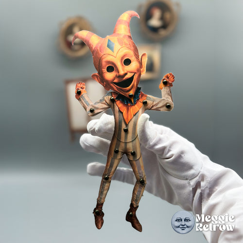 Pip Whimsy, a printable articulated paper doll. A jester in gray and peach stripes with a curled cap.