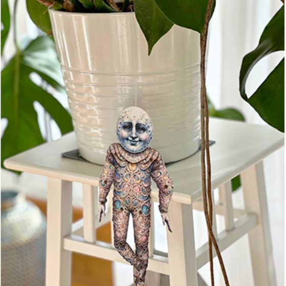 A doll held up by a paper clip stand