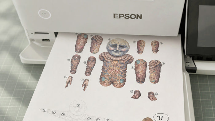 Cutting out a paper doll with small scissors