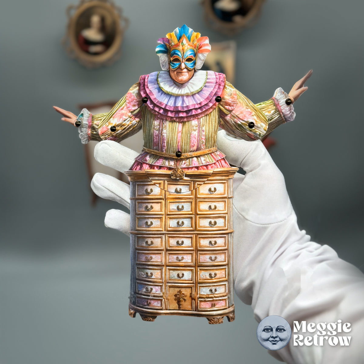 Mystic Bureau, a printable articulated paper doll. A carnival mask and ruffles on top of a wooden cabinet.