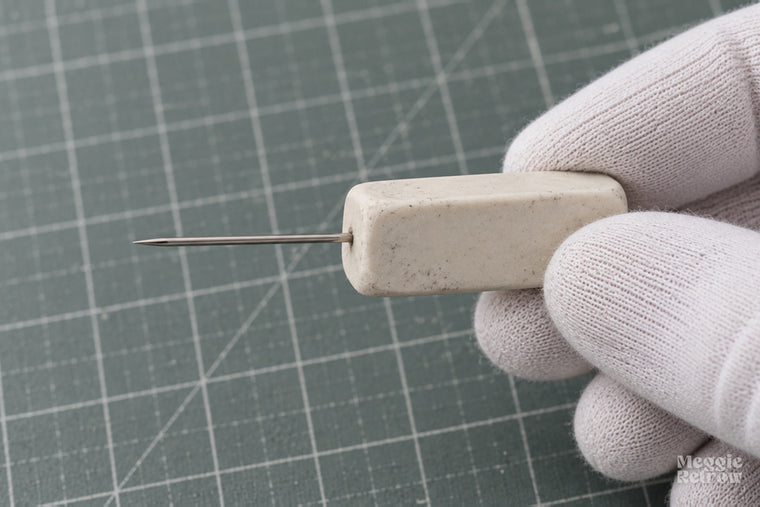 Needle pushed into an eraser